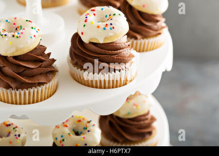 Muffins mit Schokolade Zuckerguss und kleine donuts Stockfoto