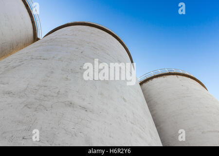 Abstrakte Industriearchitektur Fragment, machte großen Tanks aus Beton für die Lagerung von Schüttgütern unter blauem Himmel Stockfoto