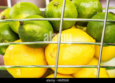 Zitronen und Grünen Limetten in den Metallkorb. Gesunde Ernährung. Obst-Szene hautnah. Erfrischende Zutaten. Quelle für Vitamine. Stockfoto