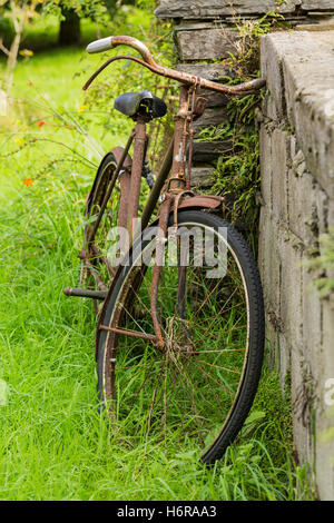 Altes Fahrrad links nach Rost lehnte sich gegen eine Wand in der Union Halle, County Cork, Irland Stockfoto