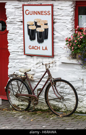 Altes Fahrrad und Guinnes Werbung außen An Lehren Beag, kleines Haus, Pub in der Union Halle, Glandore, County Cork, Irland Stockfoto