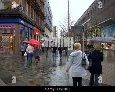 Glasgow in den Regen nassen Straßen und Sonnenschirm Sonnenschirme Einkaufstaschen Stockfoto