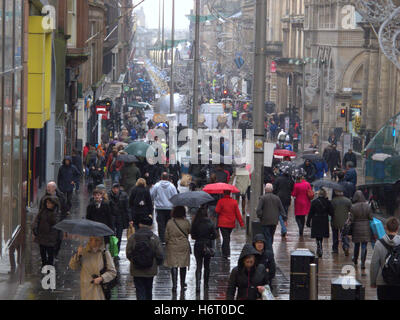 Glasgow in den Regen nassen Straßen und Sonnenschirm Sonnenschirme Einkaufstaschen Stockfoto