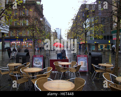 Glasgow in den Regen nassen Straßen und Sonnenschirm Sonnenschirme Einkaufstaschen Stockfoto