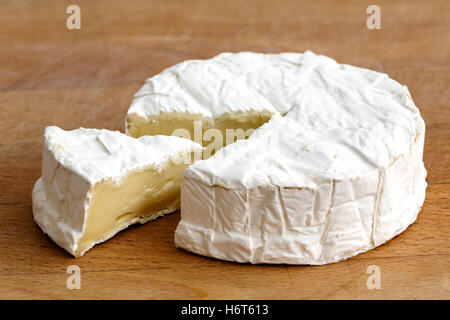 Weißer Schimmel Käse mit geschnittenen Scheibe isoliert auf Holz. Stockfoto