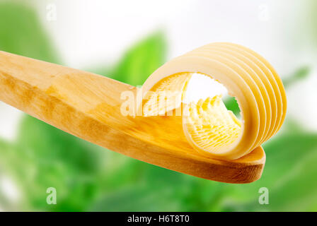 Lebensmittel Nahrungsmittel Closeup verbreiten eine gerollte Holzlöffel Curl Molkerei Margarine Milch Produkt Zutat gewellt Butter frische Lebensmittel Stockfoto