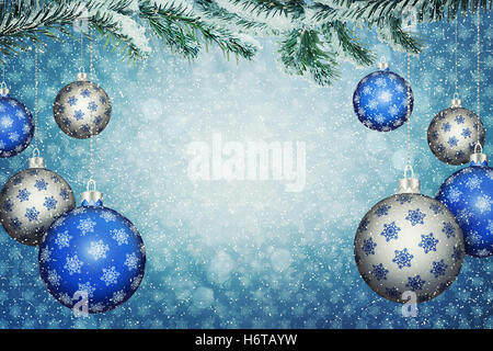 Satz von blauen und silbernen Kugeln mit Schneeflocke Muster hängen an einem verschneiten Tannen Ast. Weihnachten und Neujahr Hintergrund mit Kopie spac Stockfoto