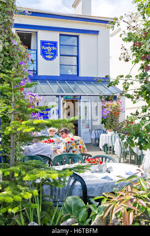 Touristen sitzen und genießen Tee im Garten des angelstea Zimmer, Babbacombe, Torquay, Devon, UK an einem sonnigen Tag Stockfoto