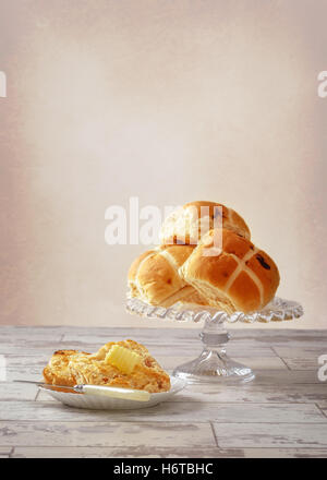 Portion heiße Kreuz Brötchen mit Butter curl Stockfoto