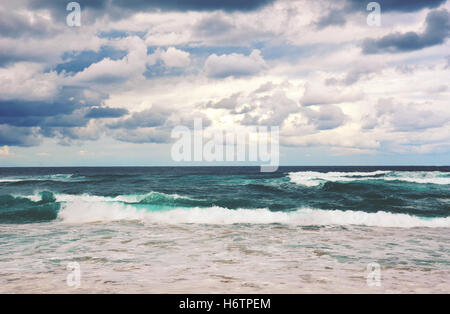 Retro-getönten dramatische stürmischen Strand-Szene. Graue Wolken und rauer See auf einem verlassenen Garie Strand, Royal National Park, NSW Stockfoto