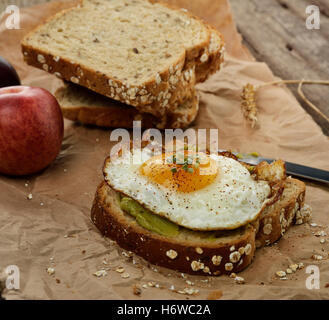 Gewürz Ei Sandwich Stück gebratene Avocado essen Nahrungsmittel Brot Gewürz Closeup Obst Weizen Ei Sandwich aus Holz geschnittene Brotscheibe Stockfoto