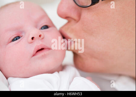 Mutter küssen Baby auf Wange Stockfoto