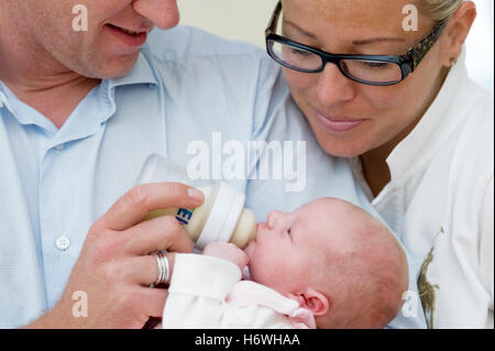 Eltern Baby mit Milchflasche füttern Stockfoto