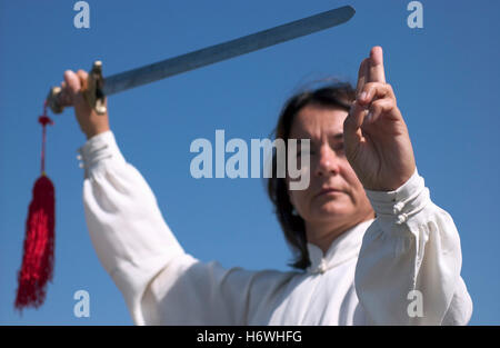 Frau, Anfang 40, mit einem Schwert Tai Chi zu tun Stockfoto