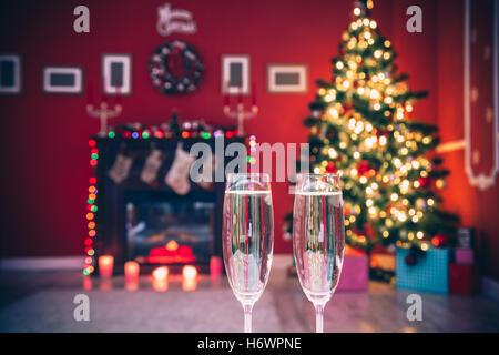 Schöne zwei Gläser Champagner stehen auf dem Tisch im Hintergrund eine verschwommene Raum mit einem geschmückten Weihnachtsbaum und Stockfoto