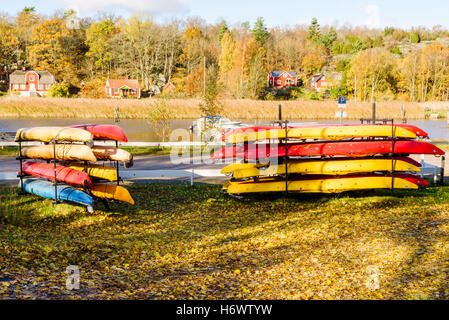 Jarnavik, Schweden - 25. Oktober 2016: Der Dokumentarfilm von Küsten Lebensstil. Rack von bunten Kajaks im Herbst am Ende Stockfoto