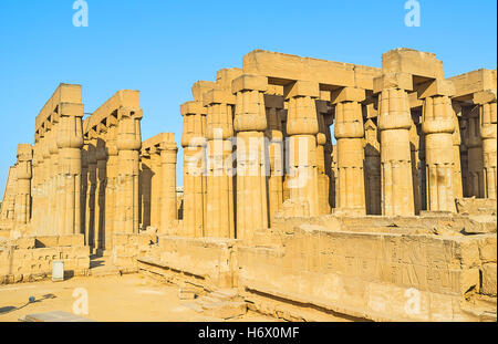 Die gut erhaltenen Spalten mit zerstörten Mauern benachbarten erfasst mit den Hieroglyphen, Skulpturen und Statuen im Luxor-Tempel Stockfoto