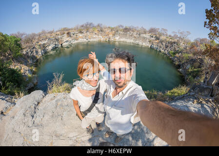 Paar mit ausgestreckten Armen nehmen Selfie Otjikoto See, eines der nur zwei permanente Natursee in Namibia, Afrika. Con Stockfoto