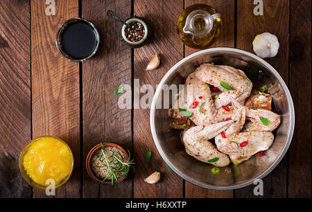 Roh marinierte Hühnerflügel im asiatischen Stil mit Honig, Knoblauch, Soja-Sauce und Kräutern zubereitet. Ansicht von oben Stockfoto