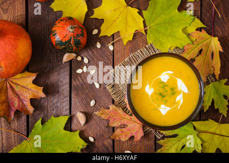 Sahne Kürbis Suppe mit Sauerrahm-Sauce. Halloween. Ansicht von oben Stockfoto