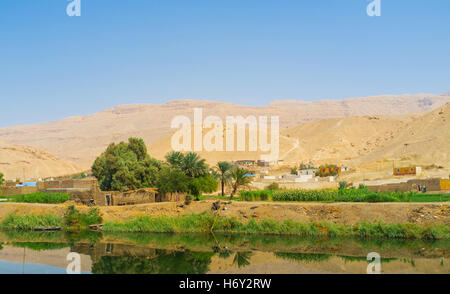 Die alten Häuser befindet sich auf der Wüste Hillwith den Kanal des Flusses Nil im Vordergrund, Ägypten. Stockfoto