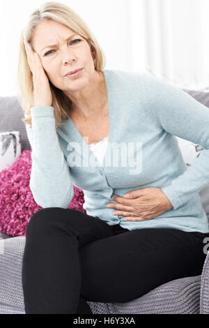 Reife Frau Magenschmerzen und Kopfschmerzen leiden Stockfoto