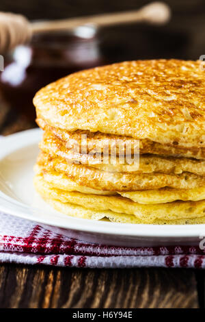 Pfannkuchen. Stapel von Pfannkuchen mit Honig, traditionelle russische Pfannkuchen - Blini auf hölzernen Hintergrund Stockfoto