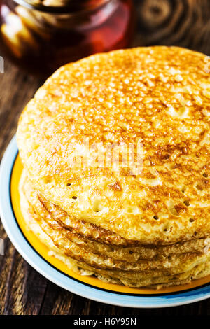 Pfannkuchen. Stapel von Pfannkuchen mit Honig, traditionelle russische Pfannkuchen - Blini auf hölzernen Hintergrund Stockfoto
