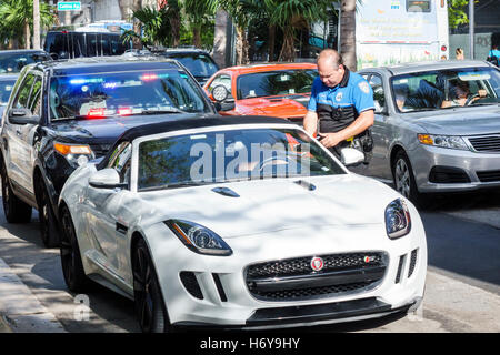 Miami Beach Florida, Polizei, Polizist, Schreiben Ticket, Verkehr, geben Fahrer, Sportwagen, Besucher reisen Reise touristischer Tourismus Wahrzeichen Land Stockfoto