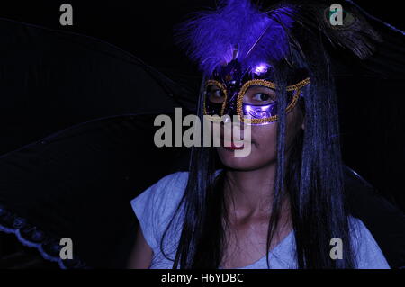 Portrait einer Khmer Frau mit dunkler Haut, die eine Maskerade für eine Halloween Party trägt, Phnom Penh, Kambodscha. © Kraig Lieb Stockfoto