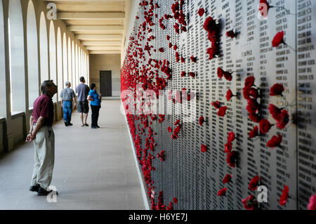 Besucher verlassen rotes Papier Mohn in Ehrenrolle Wand für die lieben in der Tätigkeit getötet. australische Kriegsdenkmal. Canberra. handeln