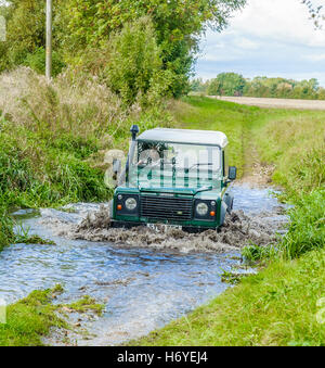 Ein Landrover Defender 90 überqueren oder fording, einem Bach oder Fluss Stockfoto