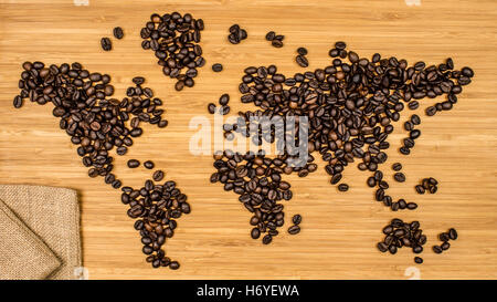 Karte der Welt von gerösteten Arabica Kaffeebohnen Handauflegen Bambus Holz strukturierten Hintergrund Stockfoto