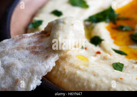 Detail der Hummus auf Pita-Brot. Teller mit Hummus im Hintergrund. Stockfoto