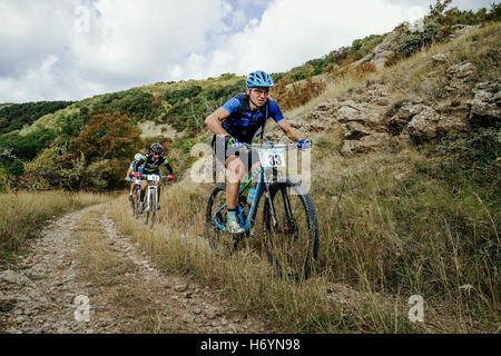 Gruppe von Fahrern Radfahrer bergauf auf einem Waldweg in Krim Rennen mountainbike Stockfoto