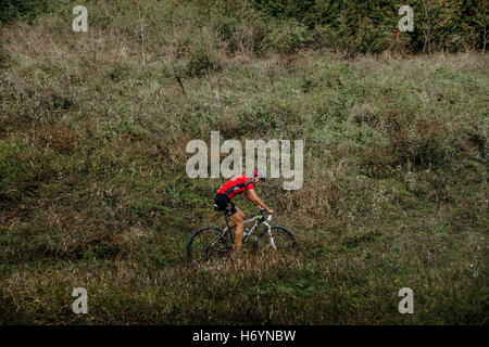 Racer Mountainbiker Fahrten am Berghang im Rasen während Krim Rennen mountainbike Stockfoto