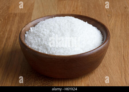 Dunkles Holz Schale mit getrockneten Kokosnuss auf Holztisch. Stockfoto