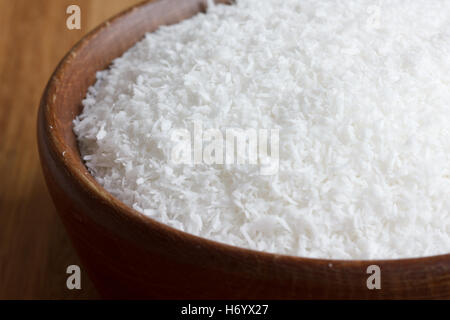 Dunkles Holz Schale mit getrockneten Kokosnuss auf Holztisch. Stockfoto