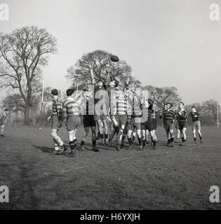 konkurrieren Sie 1950er-Jahren, historische, Rugby zu spielen, nach vorne, gewinnt den Ball in einen Line-out an ein Amateur Rugby-union-Spiel, England, UK. Stockfoto