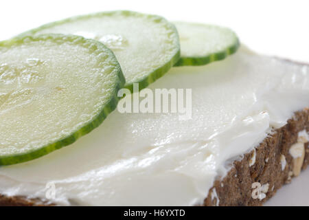 Gurke in dünne Scheiben geschnitten auf dick Ausbreitung Frischkäse auf dunklen Gesundheit Brot. Stockfoto