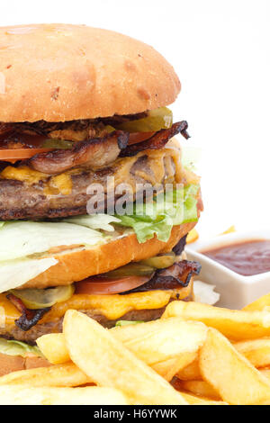 Doppelte Cheeseburger und Pommes mit Ketchup auf einem weißen Teller. Stockfoto