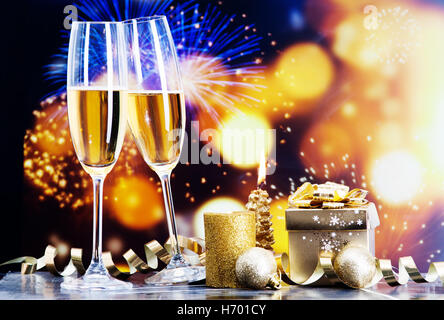 Toasten mit Champagner-Gläser gegen Weihnachtslichter und Silvester Feuerwerk Stockfoto