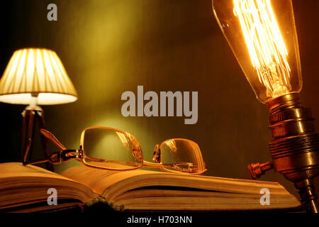 Altes Buch und Brille mit Vintage Lampe. Retro-Stil. Stockfoto