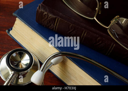 Stethoskop mit Büchern auf einem hölzernen Hintergrund. Medizinische Ausbildungskonzept. Stockfoto