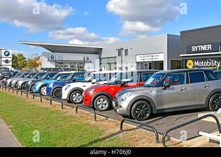 Eine Reihe gebrauchter BMW Mini-Gebrauchtwagen zum Verkauf auf dem Vorplatz des Händlers vor dem Ausstellungsraum des Sytner Motability-Autohauses in London, England, Großbritannien Stockfoto