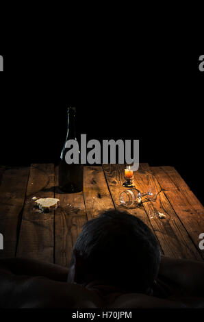Betrunkener Mann schlief auf einem schmutzigen Tisch. Stockfoto