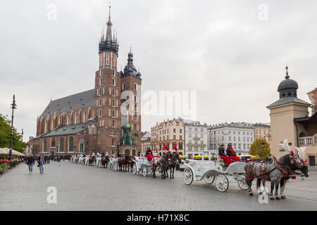 Krakau, Polen - 27. Oktober 2016: Traditionelle Pferdekutschen für Passagiere auf Krakauer Hauptmarkt in der Schlange warten. Stockfoto