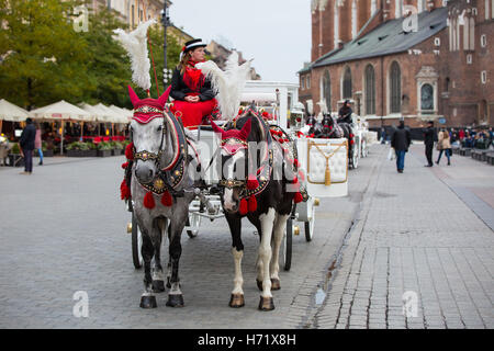 Krakau, Polen - 27. Oktober 2016: Traditionelle Pferdekutsche auf Krakauer Hauptmarkt für Passagiere warten. Stockfoto