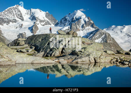 Reflexion der Wanderer unter Piz Bernina und Piz Rosbeg. Fuorcla Surlej, Silvaplana, Berniner Alpen, Graubünden, Schweiz. Stockfoto