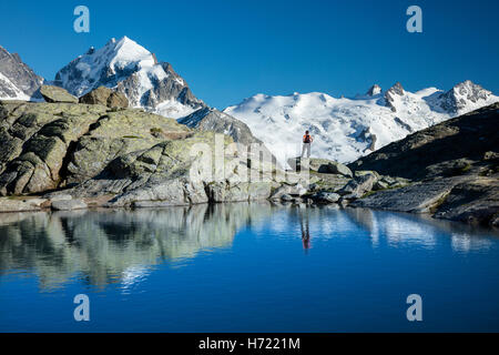 Reflexion der Wanderer unter Piz Bernina und Piz Rosbeg. Fuorcla Surlej, Silvaplana, Berniner Alpen, Graubünden, Schweiz. Stockfoto